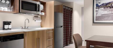 Una cocina moderna con electrodomésticos de acero inoxidable, armarios de madera y un comedor con mesa y sillas.