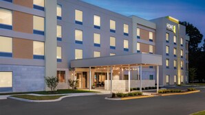 Un hôtel moderne doté d’une entrée couverte, de plusieurs étages et d’une façade bien éclairée.