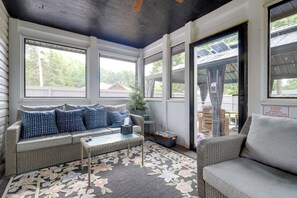 A sunroom with a sofa, a small table, and a potted plant. - Chic Family-Friendly Home in Riverside: 7 Mi to KC (Riverside)