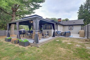 A covered patio with outdoor furniture, a fire pit, and planters. - Chic Family-Friendly Home in Riverside: 7 Mi to KC (Riverside)