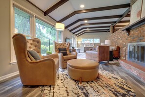 A spacious living room with leather furniture, large windows, and a fireplace. - Chic Family-Friendly Home in Riverside: 7 Mi to KC (Riverside)
