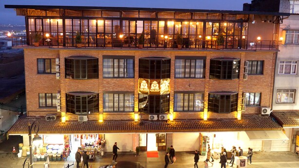 A multi-story building with a restaurant on the upper floor, featuring large windows and a balcony. - Sur Central Hotel (Diyarbakir)