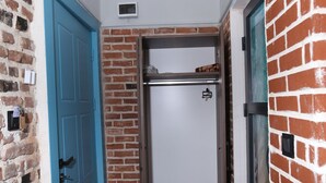 A narrow hallway with a blue door, a white door, and a brick wall. - Sur Central Hotel (Diyarbakir)