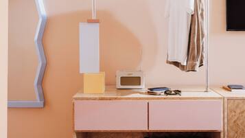 A modern room with a wooden dresser, a radio, and a clothing rack.
