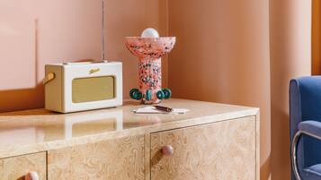 Una habitación con un armario de madera, una radio antigua y un objeto decorativo encima.