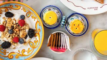 Un desayuno con diferentes platos, como panqueques, huevos y una ensalada de frutas.