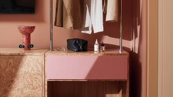 Un tocador con espejo, un lavabo rosa y un mueble de madera con zapatos.