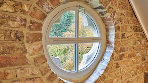 A round window with a white frame, set in a brick wall. - Highfield House (Ripon)