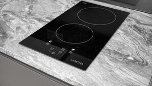 A black induction cooktop with a control panel on a marble countertop. - Luxury Studio in London (London)