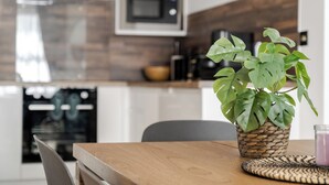 A modern kitchen with a wooden table, a potted plant, and a microwave. - LONDONERS│Marylebone Serviced Apartments  (London)