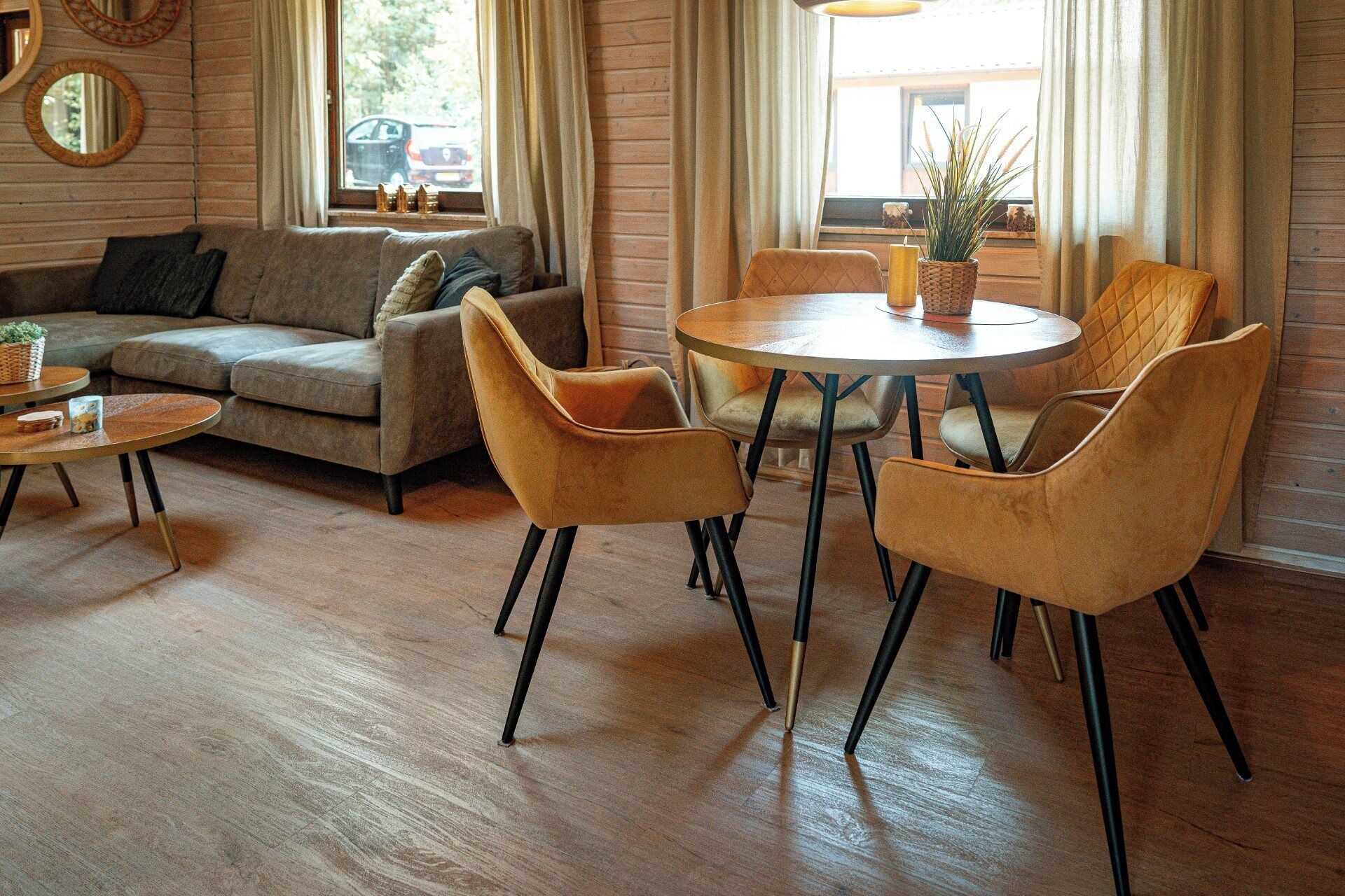 A cozy living room with a sofa, a round coffee table, and four chairs.