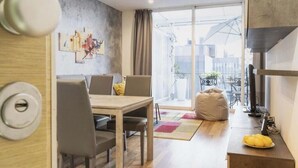 Uma sala de estar moderna com área de jantar, uma janela grande e vista para a cidade.