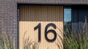 A building with a large number '16' displayed on a wooden panel. - Studio - Van der Manderelaan 16 'Studio B' | Koudekerke (Koudekerke)