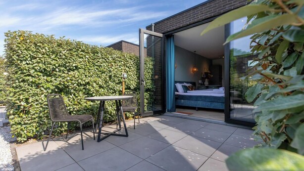 Un patio moderno al aire libre con puerta de vidrio que da a un dormitorio.