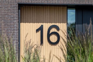 A building with a large number '16' displayed on a wooden panel.