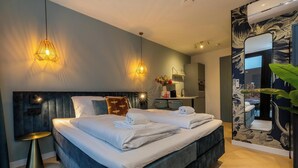 Un dormitorio moderno con una cama grande, mesitas de noche y una pequeña zona de escritorio.