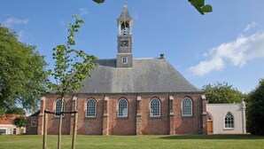 Una iglesia con una torre de campanario y ventanas de arco.