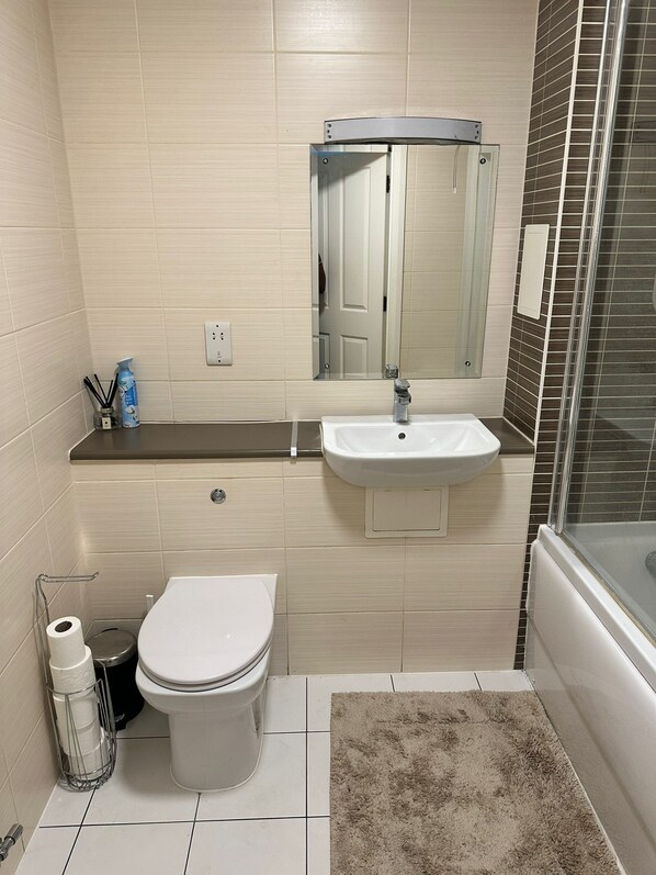 A bathroom with a toilet, sink, and shower. - Cosy1-bed Apartment in London Near Excel London (London)