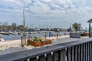 Guests can enjoy waterfront views from the marina's seating area, surrounded by lush gardens and a wooden fence.