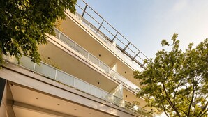 A modern building with a glass entrance, a covered outdoor area, and a car parked nearby. - GURRUCHAGA PALERMO (Buenos Aires)