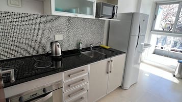 Deluxe Apartment | Private kitchen | Full-size fridge, microwave, oven, toaster