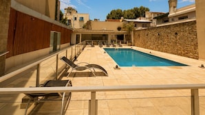 A swimming pool with a stone wall and a clear blue sky. - GURRUCHAGA PALERMO (Buenos Aires)