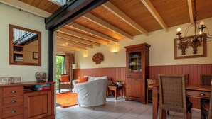 Ein gemütliches Zimmer mit Bett, Holzmöbeln, einem Essbereich und einem großen Fenster.