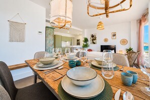 A dining area with a wooden table set for a meal, surrounded by chairs.