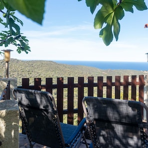 Two outdoor chairs with a view of a hilly landscape and the sea. - Casa Cedro in Luddui (Budoni)