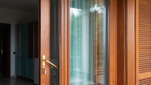 A wooden door with a glass panel and a brass handle. - La Casa di Salvatore (Budoni)