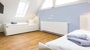 Une chambre moderne avec un lit en mezzanine, une table de chevet et une fenêtre.