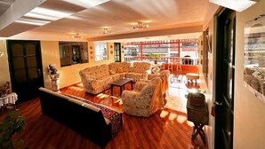A spacious living room with a large sectional sofa, a coffee table, and a dining area with a table and chairs. - Hotel Willcamayu  (Pisac)