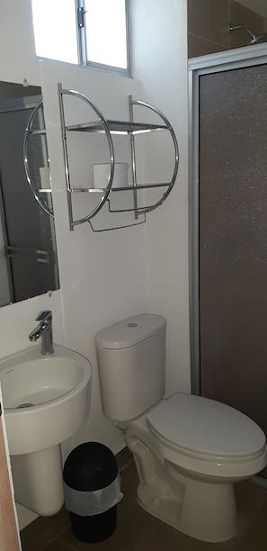 A bathroom with a toilet, sink, and mirror. - Apartment in New Condominium in Bello Horizonte Plaza SMR with elevator (Santa Marta)