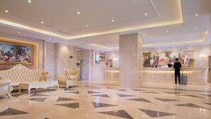 A spacious lobby with a reception desk, plush seating, and a patterned floor. - Vienna International Hotel (Chengdu)