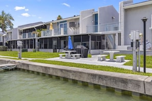 Um hotel à beira-mar com área de estar externa, piscina e um terraço coberto.