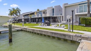 A waterfront hotel with a pool, outdoor seating, and a boat dock.