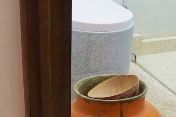 A bathroom with a white toilet and a grey speckled bathtub. - Niyana Oaxaca (Oaxaca)