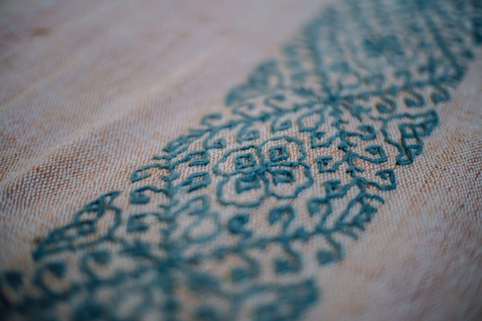 A close-up of a fabric with a detailed embroidery pattern.
