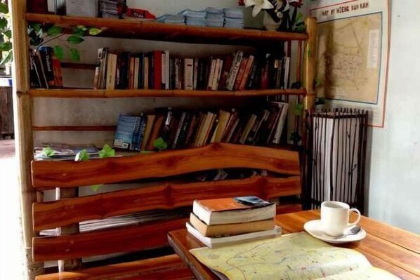 Eine Holzbank mit Büchern, einer Karte und einer Tasse auf einem Tisch.