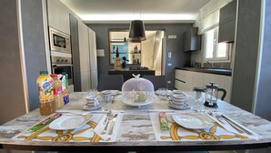 A dining table set with plates, cutlery, and a decorative centerpiece. - 2 Bedroom Villa in Gallina (Gallina)