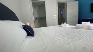 A hotel room with a neatly made bed, a hanging coat rack, and a visible bathroom door. - 2 Bedroom Villa in Gallina (Gallina)