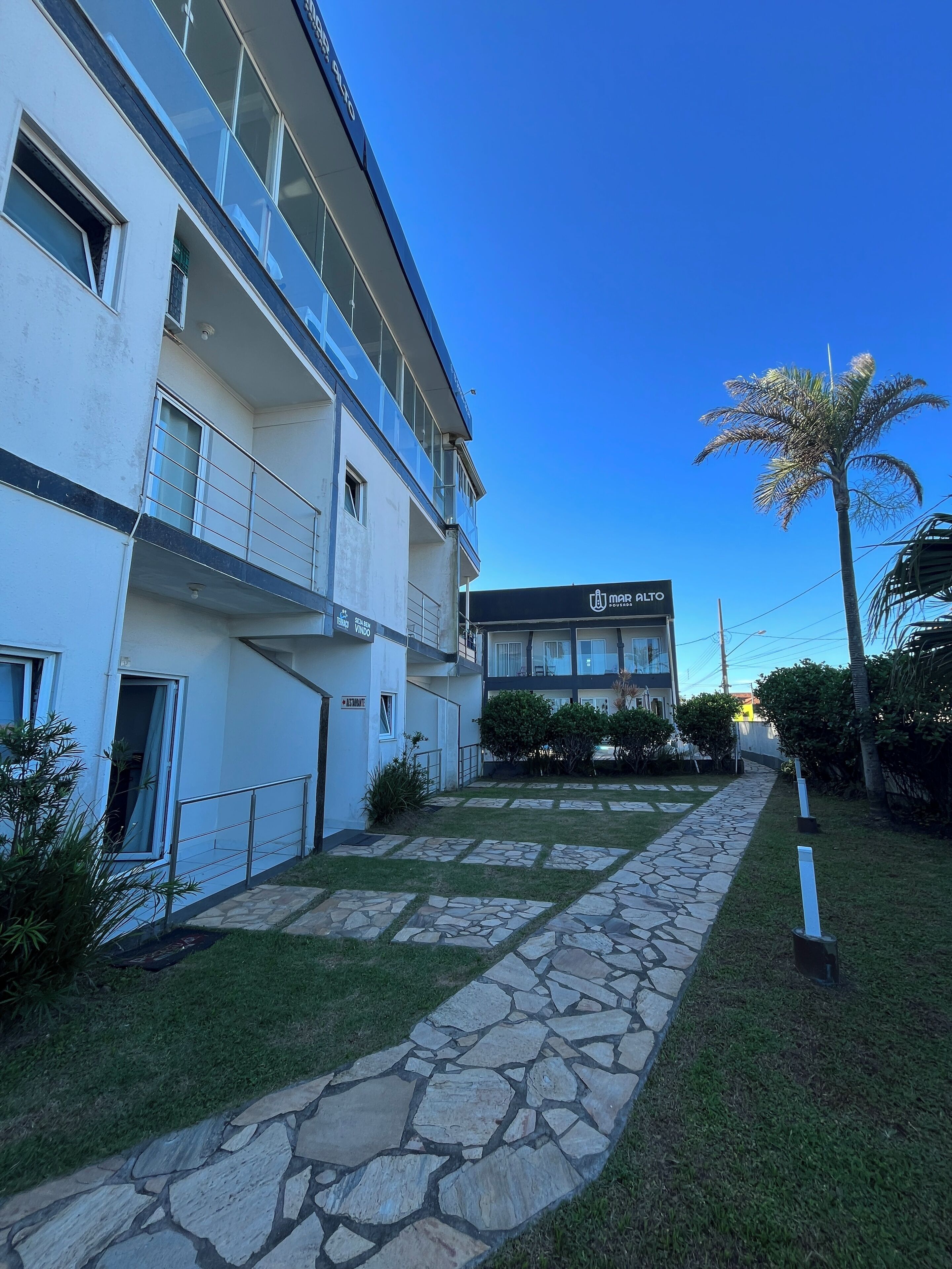 Un edificio moderno con un vialetto in pietra che conduce a un ingresso con cancello.