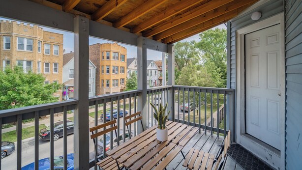 A covered porch with wooden beams, a bench, and a potted plant. - 2F - ❤️ Lowest Rates! Fun & Stylish 3BR in Logan Square (Chicago)