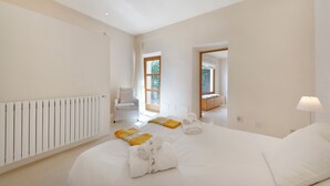 Een hotelkamer met een groot bed, een stoel, een bureau en een raam.