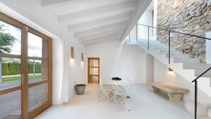 Een modern interieur met een stenen muur, een trap en een eethoek met tafel en stoelen.