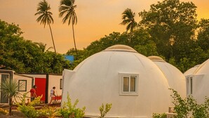 A row of dome-shaped structures with a tiled walkway in front.