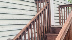 A wooden staircase with a handrail leading to a white door with a glass panel. - Cozy studio rental situated between Bedford and Lynchburg Virginia (Forest)