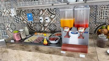Una barra de desayuno con diversas opciones de comida y dos dispensadores de bebidas.