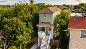 A residential property with a two-story house, a covered porch, and a small staircase leading to the upper level.