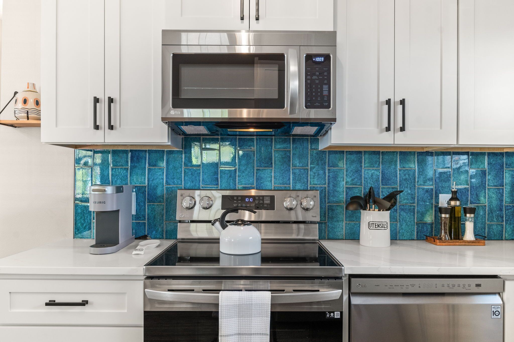 A modern kitchen with stainless steel appliances, including a microwave, oven, and dishwasher.